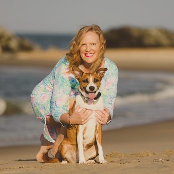 Kirsten Smith with her fur baby (dog) Samantha posing for a photo on the beach